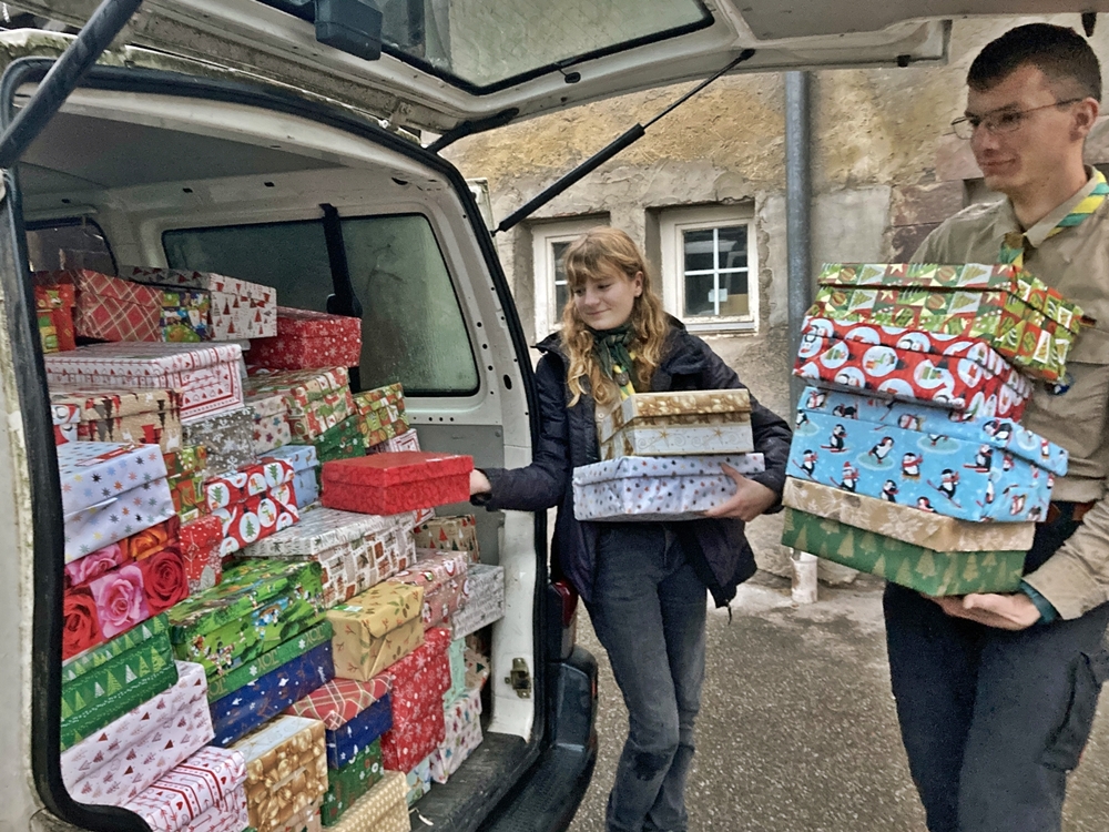 Zwei Pfadfinder verladen gepackte Geschenke