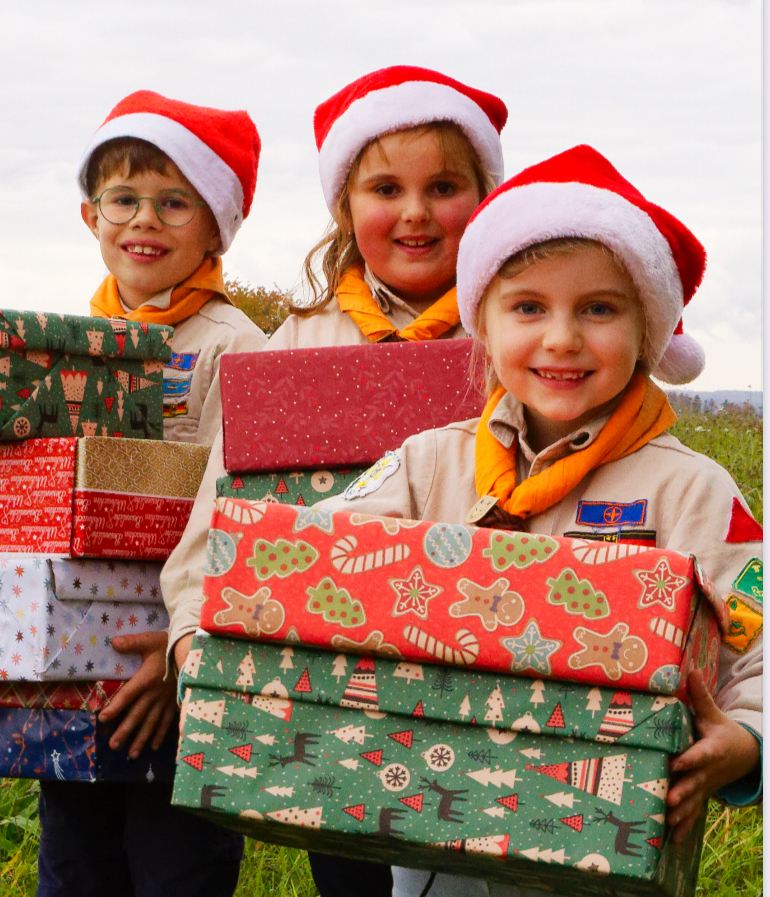 Drei Pfadfinder halten Weihnachtsgeschenke Drei Pfadfinder halten Weihnachtsgeschenke